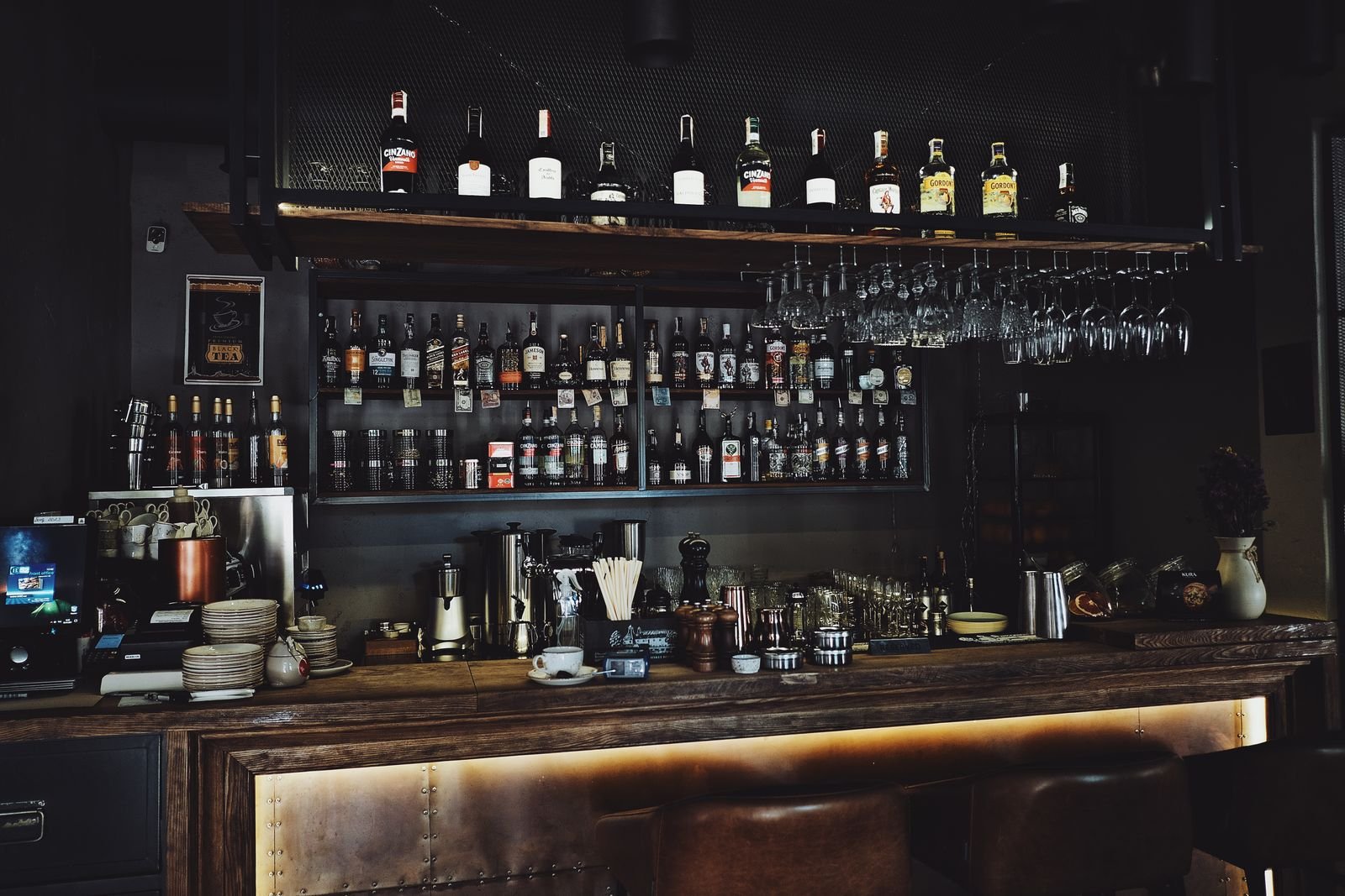 Bar com garrafas iluminado, clima de taverna